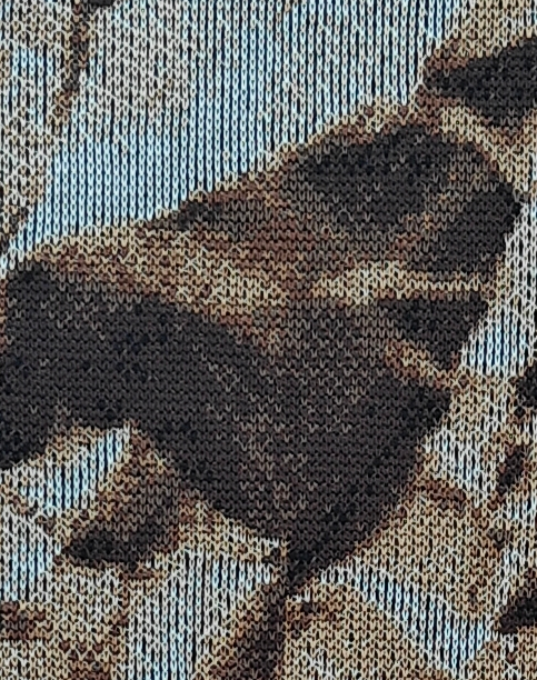 Close-up macro shot of the high-density knit structure of ArtKnitting textile art, revealing individual stitches and color transitions.